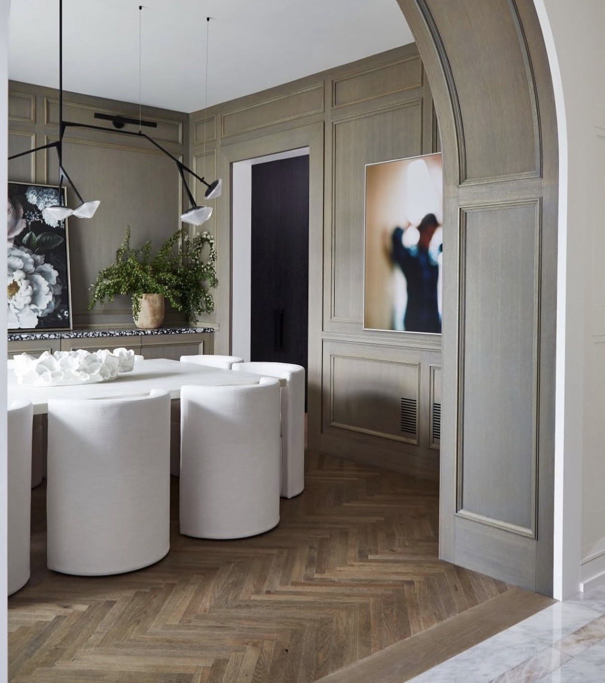 Custom wall panelling and herringbone oak floors in a paneled dining room by Anchored Interiors in a luxury Toronto home