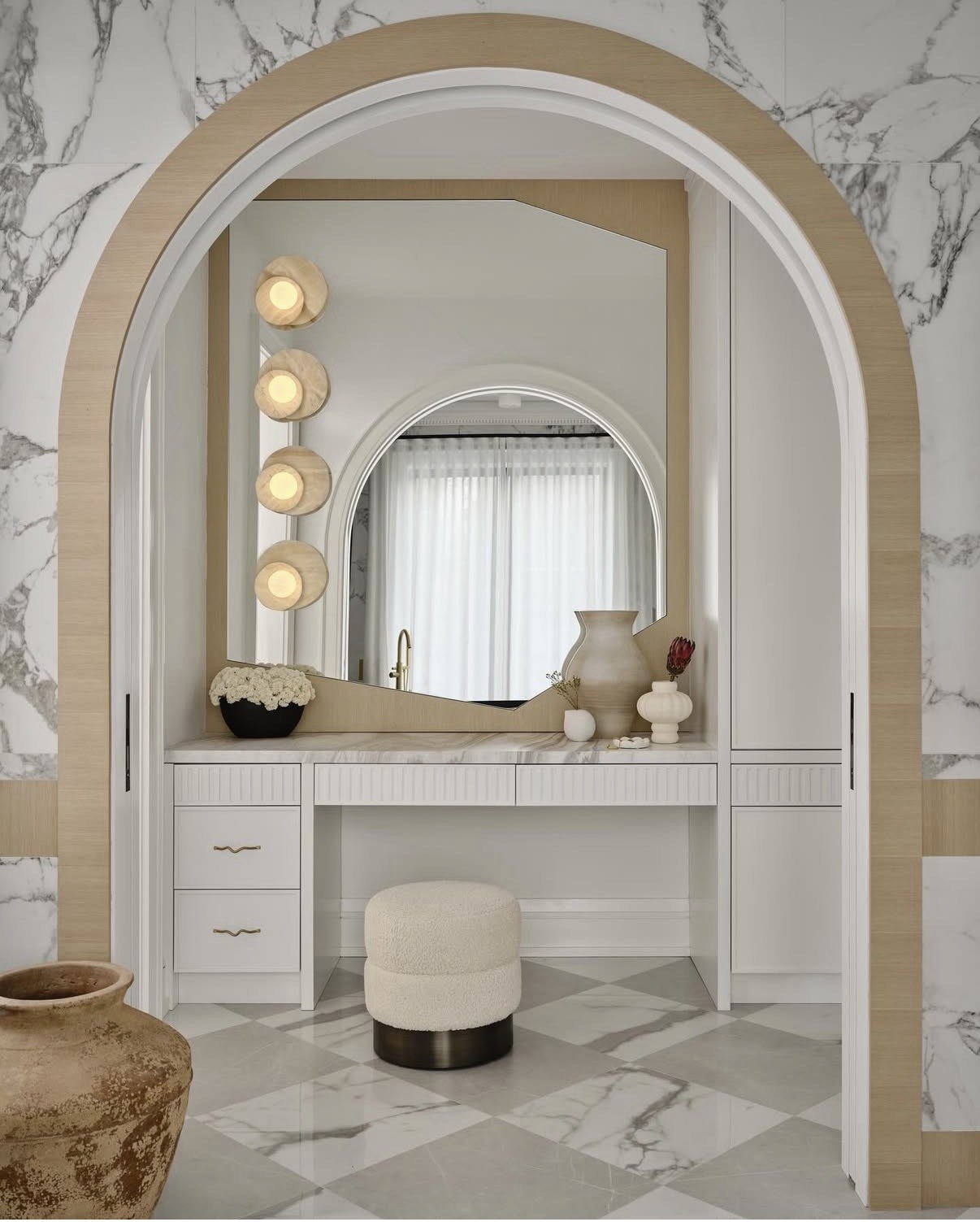 Panel-moulded vanity in arched marble opening
